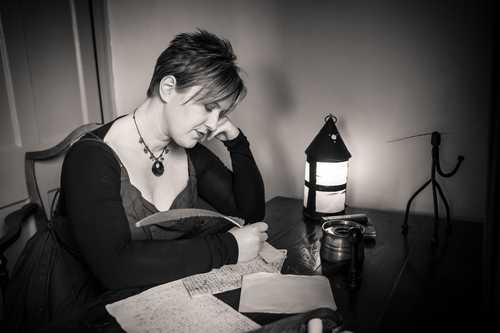 A photo of Ange Hardy working at Samuel Taylor Coleridge's writing desk
